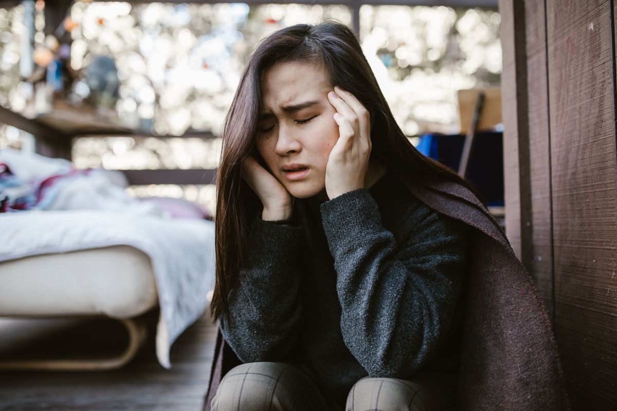 Mulher em sofrimento emocional segurando a cabeça